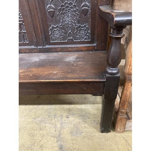 12 - A 19th century oak settle incorporating 17th century panels, width 137cm, depth 44cm, height 131cm... 