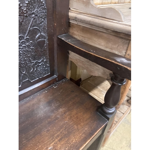 12 - A 19th century oak settle incorporating 17th century panels, width 137cm, depth 44cm, height 131cm... 