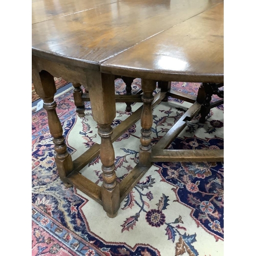 157 - An 18th century style oval oak gateleg dining table, length 150cm extended, width 122cm, height 75cm... 