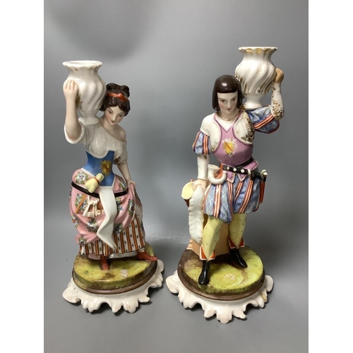 308 - A pair of Italian porcelain figures of soldiers and a pair of Continental figural candlesticks... 