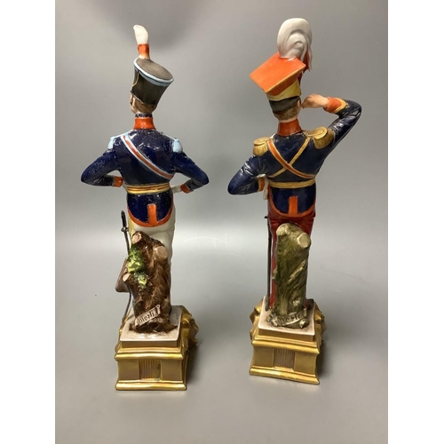 308 - A pair of Italian porcelain figures of soldiers and a pair of Continental figural candlesticks... 