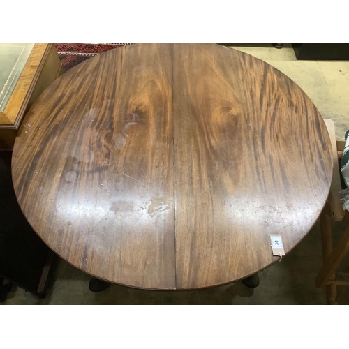 34 - A 1920's circular mahogany extending dining table with three leaves and handle, length approx. 230cm... 