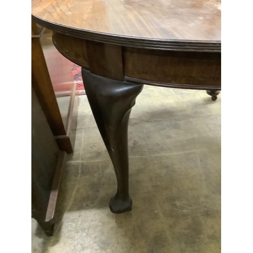 34 - A 1920's circular mahogany extending dining table with three leaves and handle, length approx. 230cm... 