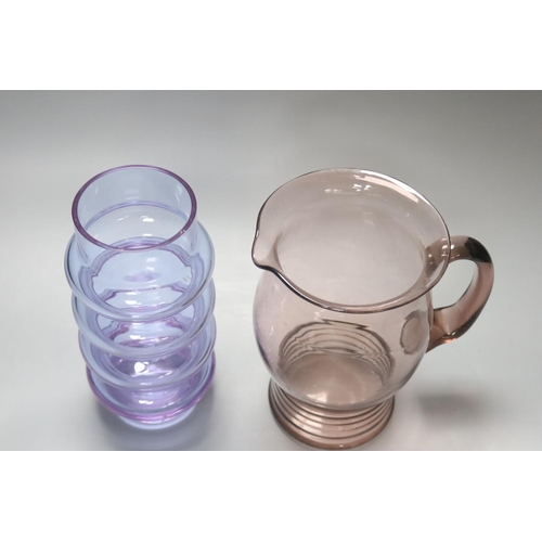 340 - An Art glass pale amethyst jug with ribbed foot and a pale blue glass cylindrical ring-form vase, he... 