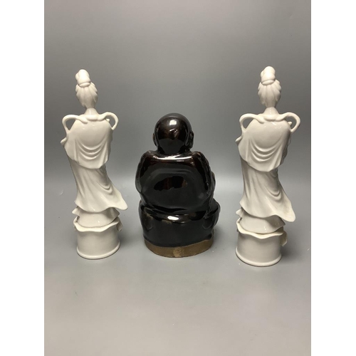 369 - A Chinese dark brown glazed Buddha, and a pair of blanc de chine figures of Guanyin, tallest 30cm... 