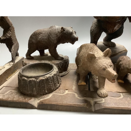 388 - A collection of Black Forest carvings - a bookslide, an ashtray and four bears