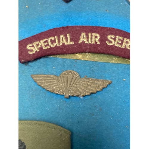 522 - A group of Special Air Service SAS embroidered insignia, a belt and other military items, includes a... 