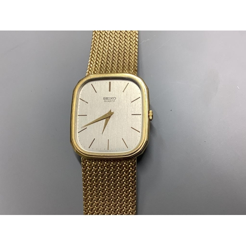 778 - A gentleman's modern 9ct gold Seiko quartz wrist watch on integral 9ct gold mesh link bracelet. over... 