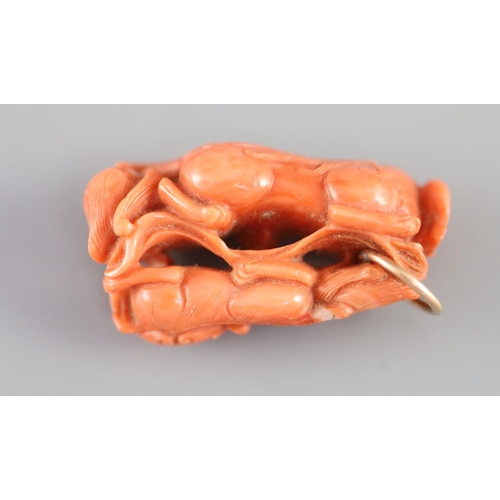 127 - A Chinese coral lion-dog pendant, 19 century,carved in high relief and openwork with two lion-dogs... 