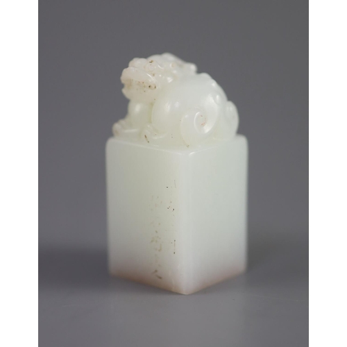 133 - A Chinese inscribed white jade seal, 20th century,surmounted by the figure of a lion-dog, the matrix... 