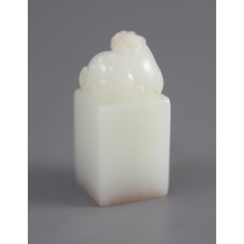 133 - A Chinese inscribed white jade seal, 20th century,surmounted by the figure of a lion-dog, the matrix... 