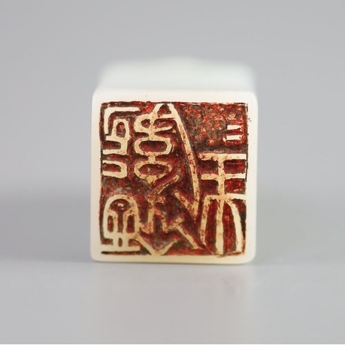 133 - A Chinese inscribed white jade seal, 20th century,surmounted by the figure of a lion-dog, the matrix... 