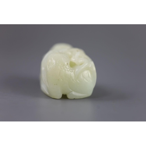 143 - A Chinese pale celadon jade group of a boy and a lion-dog, 19th/20th century,the lion-dog grasping r... 