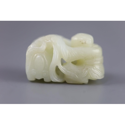 143 - A Chinese pale celadon jade group of a boy and a lion-dog, 19th/20th century,the lion-dog grasping r... 