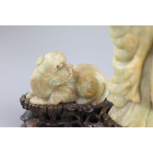 144 - A Chinese soapstone group of a luohan and a lion dog, possibly 17th/18th century,the figure holding ... 