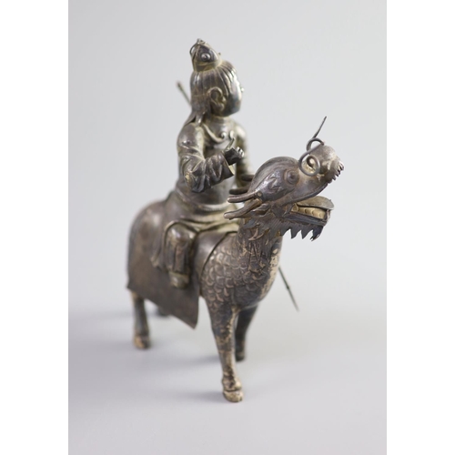 162 - A Chinese white metal model of a boy riding a qilin , early 20th century,well modelled with engraved... 