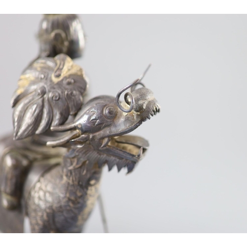 162 - A Chinese white metal model of a boy riding a qilin , early 20th century,well modelled with engraved... 