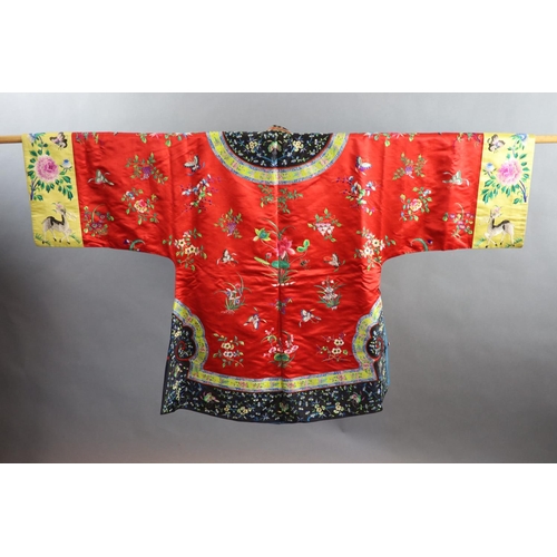 175 - A Chinese red silk robe, early 20th century,embroidered with spot motifs of butterflies, flowers and... 