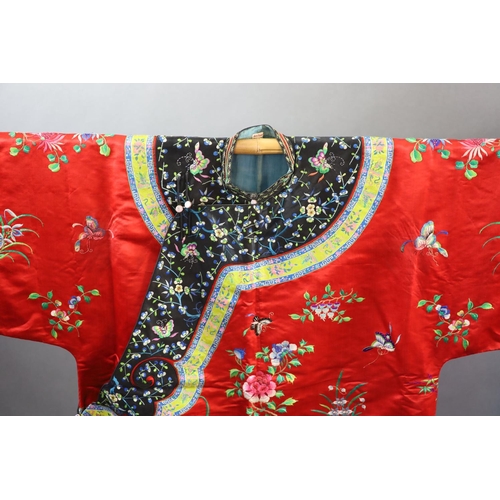 175 - A Chinese red silk robe, early 20th century,embroidered with spot motifs of butterflies, flowers and... 