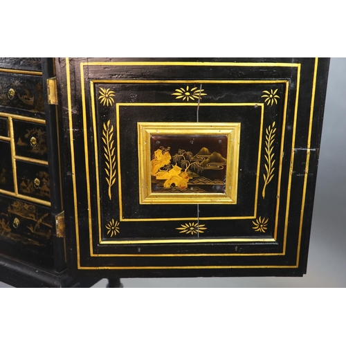 232 - An early 18th century European japanned cabinet on stand,the single panelled door with gilt brass mo... 