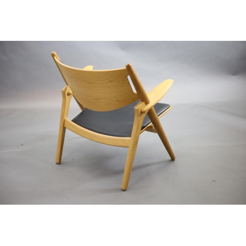 271 - Hans Wegner for Carl Hansen, an oak and oak laminate framed Sawback armchair,with black leather co... 