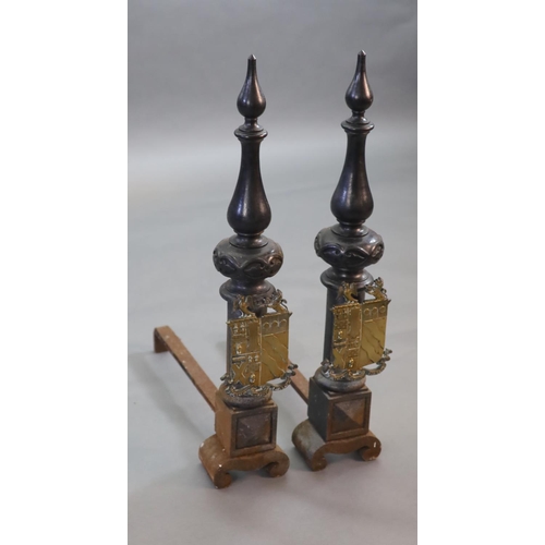 44 - A substantial pair of 19th century heraldic cast iron fire dogs,with pointed baluster finals above a... 