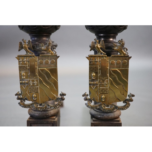 44 - A substantial pair of 19th century heraldic cast iron fire dogs,with pointed baluster finals above a... 