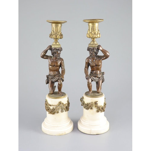 45 - A pair of 19th century bronze and ormolu figurative candlesticks,with kneeling figures raising urns,... 