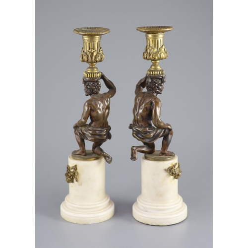 45 - A pair of 19th century bronze and ormolu figurative candlesticks,with kneeling figures raising urns,... 