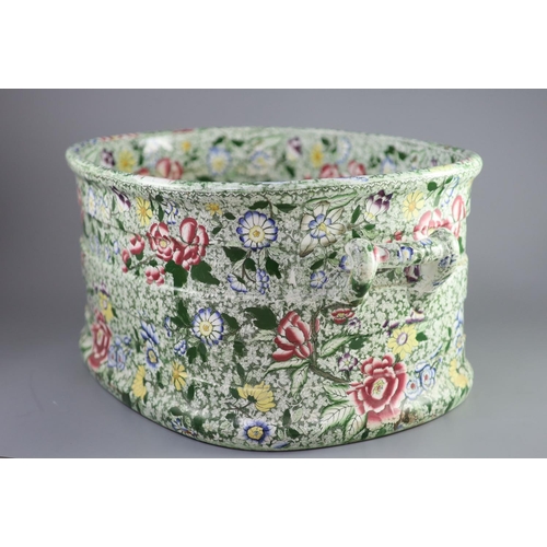 74 - A Victorian ironstone two handled footbath, c.1840,green printed and over enamelled with pink yellow... 