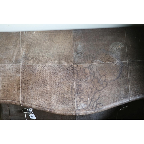 A three drawer bombe commode, upholstered in simulated snake skin