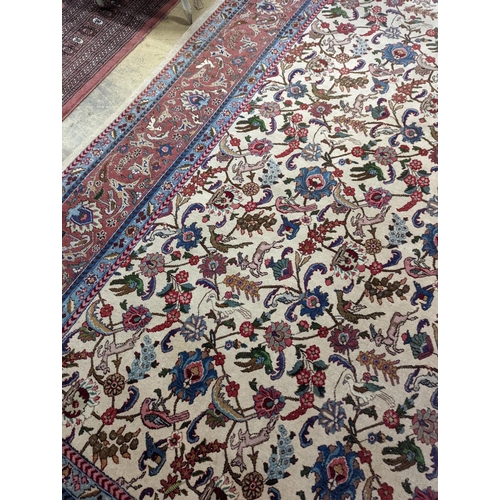 10 - An Ispahan ivory ground carpet woven with flowers and animals, 386 x 276cm