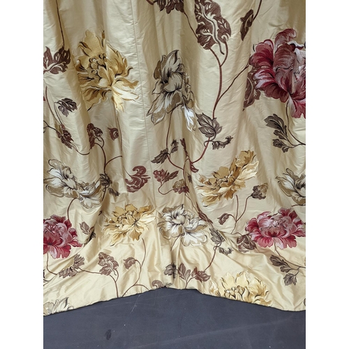 109 - A pair of floral lined curtains. Approximate measurements: Width of top 110cm, Width of bottom 220cm... 