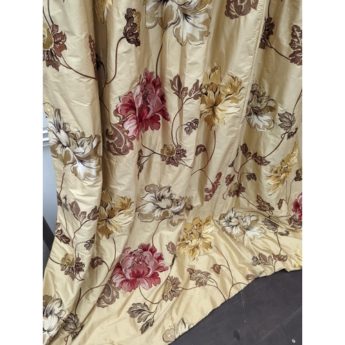 109 - A pair of floral lined curtains. Approximate measurements: Width of top 110cm, Width of bottom 220cm... 