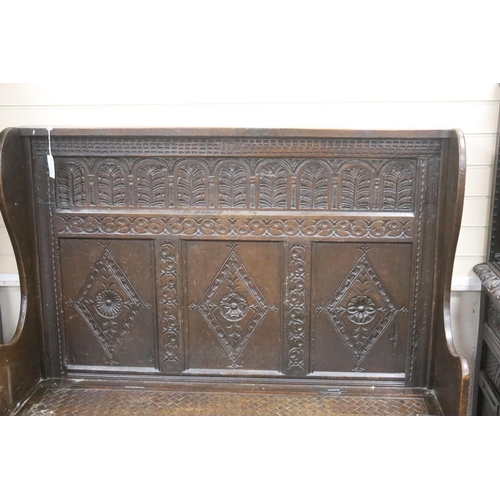 181 - An 18th century and later carved oak settle with hinged box seat, width 137, depth 42, height 137 cm... 