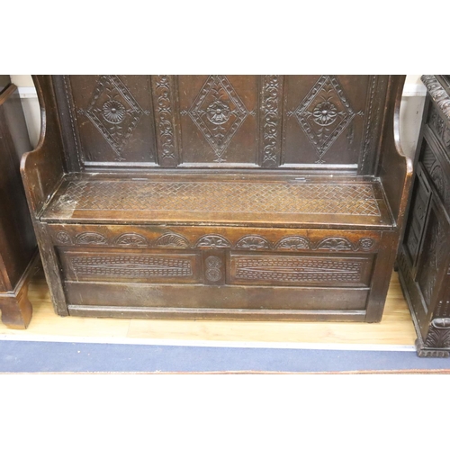 181 - An 18th century and later carved oak settle with hinged box seat, width 137, depth 42, height 137 cm... 