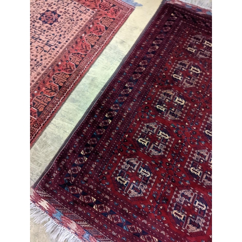 182 - A Belouch red ground rug woven with octagonal motifs,  190 x 124 cms.