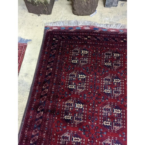 182 - A Belouch red ground rug woven with octagonal motifs,  190 x 124 cms.