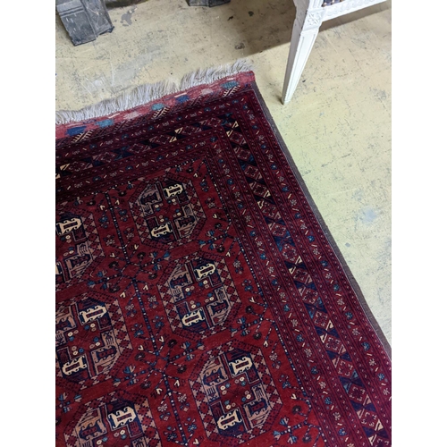 182 - A Belouch red ground rug woven with octagonal motifs,  190 x 124 cms.