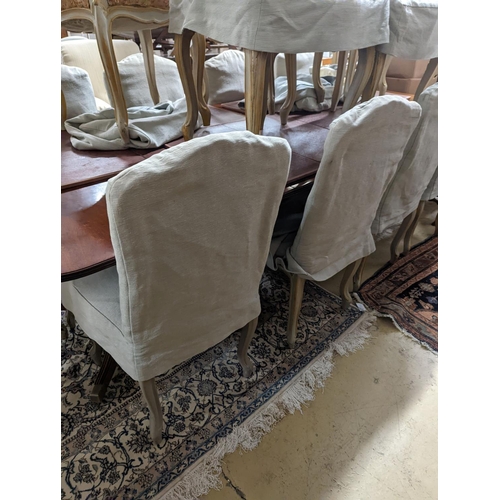 39 - A set of fourteen French Louis XV style painted upholstered dining chairs with loose covers... 