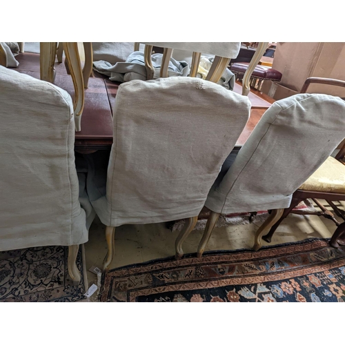 39 - A set of fourteen French Louis XV style painted upholstered dining chairs with loose covers... 