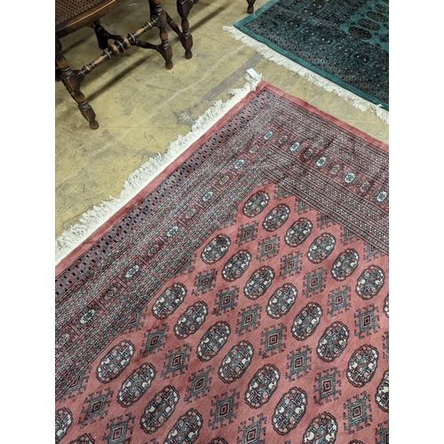 40 - A pink ground Bokhara carpet, 315 x 220cm