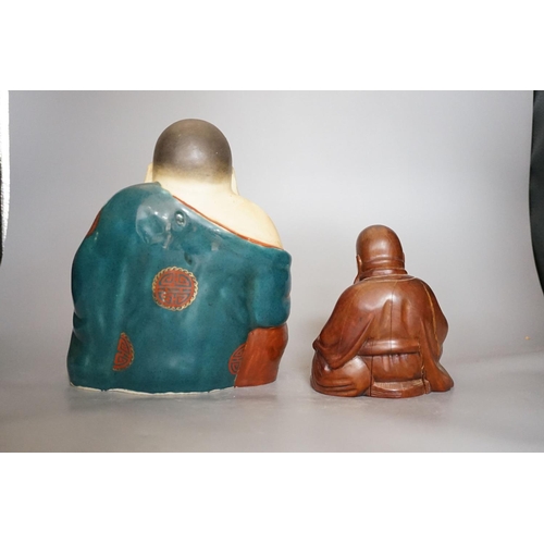 401 - A Chinese enamelled porcelain figure of Budai and a similar carved wood figure (2)