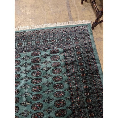 64 - A Bokhara green ground carpet, 282 x 184cm