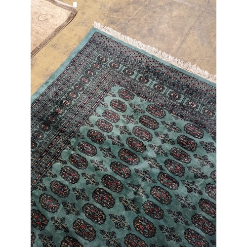 64 - A Bokhara green ground carpet, 282 x 184cm