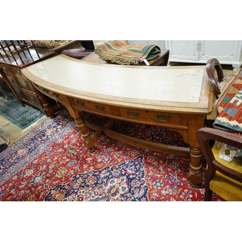 69 - A late Victorian oak four drawer library table of curved rectangular form, length 240cm, depth 60cm,... 