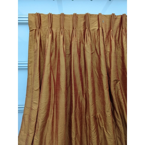 86 - A pair of orange lined curtains. Approximate measurements: Width of top 180cm, Width of bottom 320cm... 