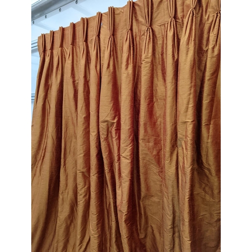 86 - A pair of orange lined curtains. Approximate measurements: Width of top 180cm, Width of bottom 320cm... 