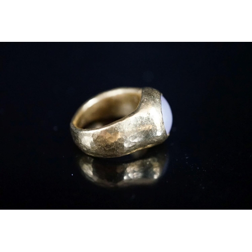 960 - A planished yellow metal (inscribed 24k) and mother of pearl mounted ring, indistinctly signed, size... 