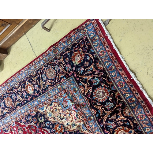 99 - A Kashan burgundy ground carpet, 380 x 300cm